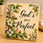 Square wooden coaster featuring the uplifting message “God’s Plan Is Perfect” in elegant black typography. Decorated with delicate white and blush pink blossoms, green leaves, and botanical branches on a natural wood grain background. Rustic farmhouse-style Christian décor perfect for coffee tables, desks, kitchens, prayer rooms, and inspirational gifts. Ideal for faith-based home décor, religious gifts, encouragement gifts, church events, Mother's Day, birthdays, and everyday reminders of hope and trust in God's plan.